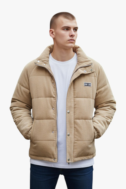 Man wearing a beige quilted jacket on a white background