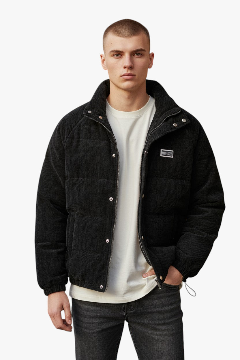 Man wearing a black jacket over a white shirt on a white background