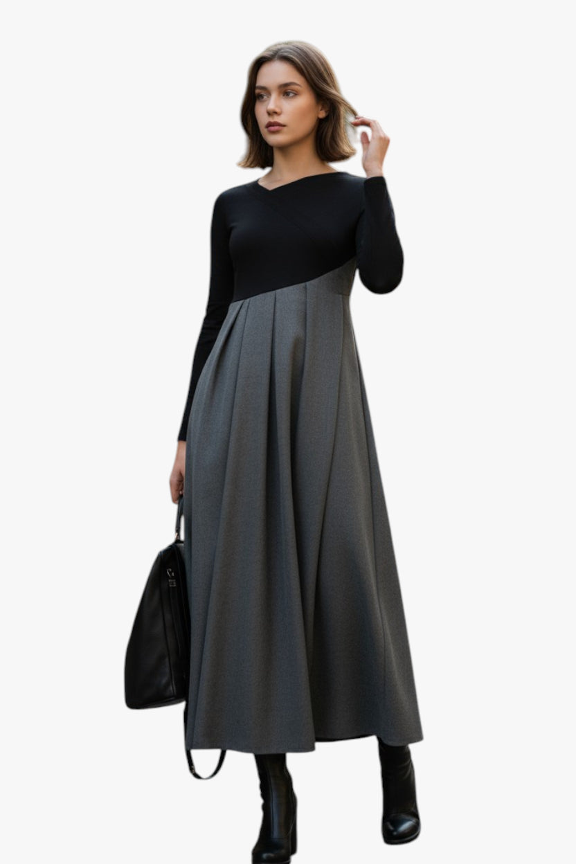 Woman wearing a black and gray dress with a black handbag on a white background