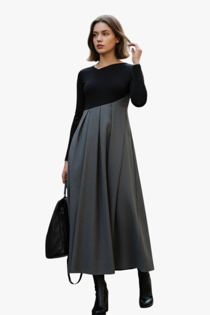 Woman wearing a black and gray dress with a black handbag on a white background