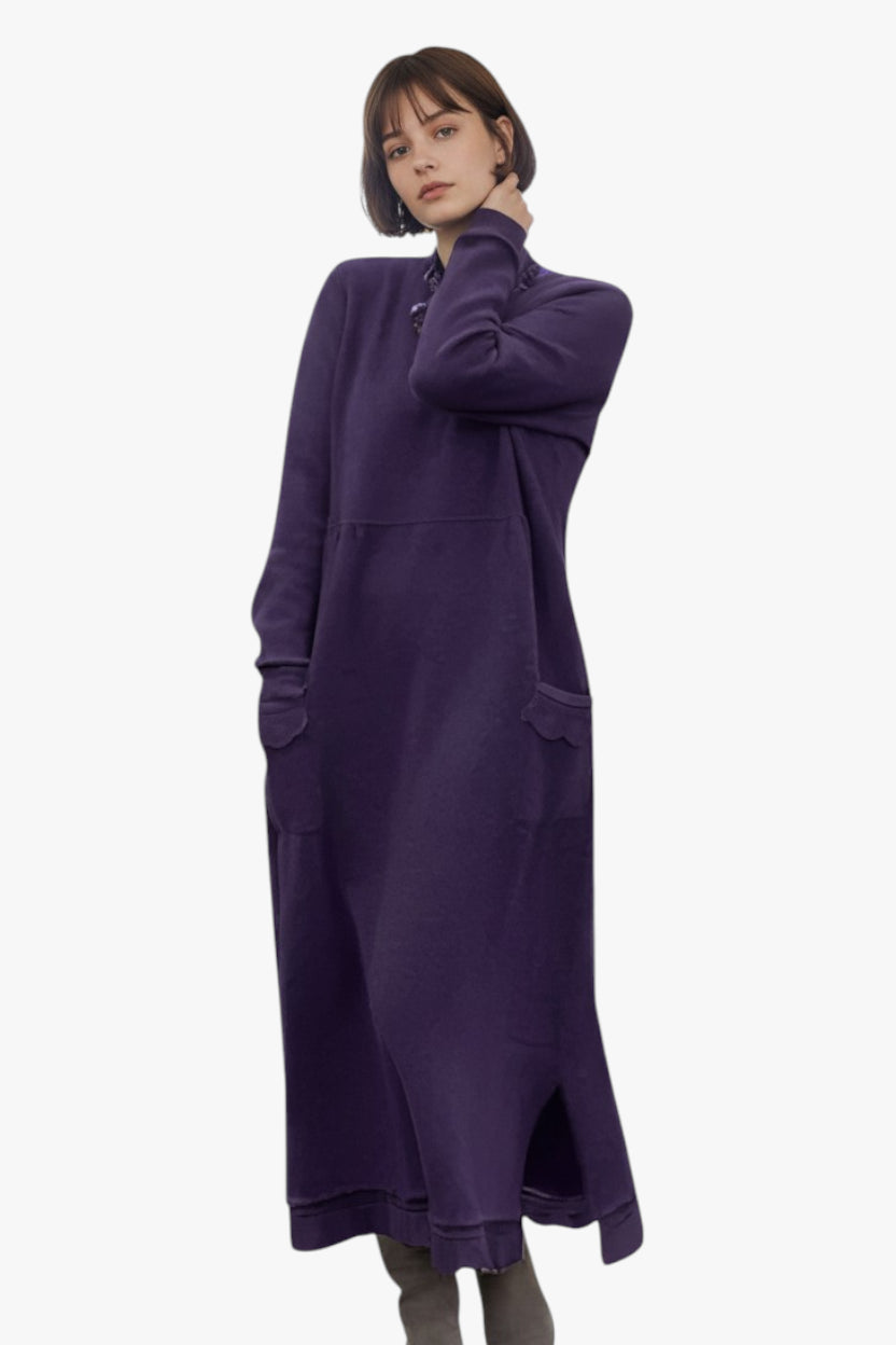 Woman wearing a long purple dress on a white background