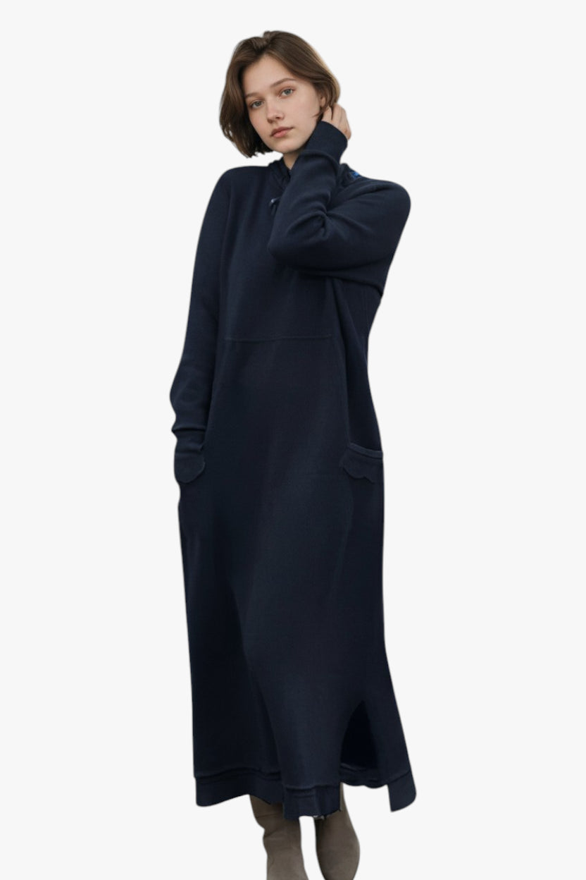Woman wearing a long navy blue dress on a white background