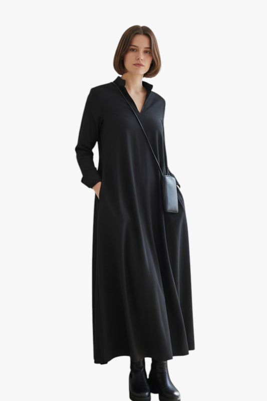 Woman wearing a black long-sleeve dress with a white background