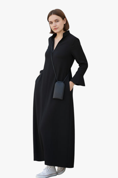 Woman wearing a black dress with a matching bag on a white background