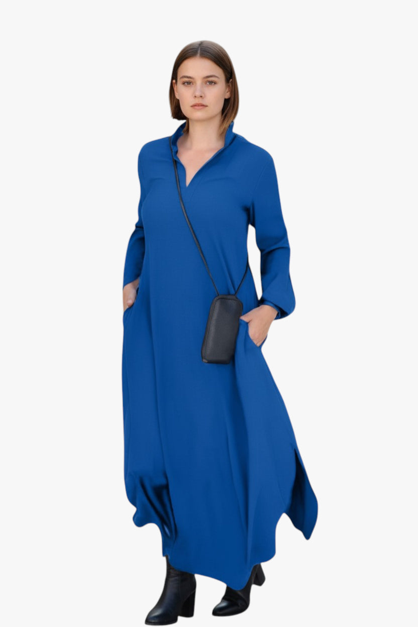 Woman wearing a blue dress holding a black handbag on a white background