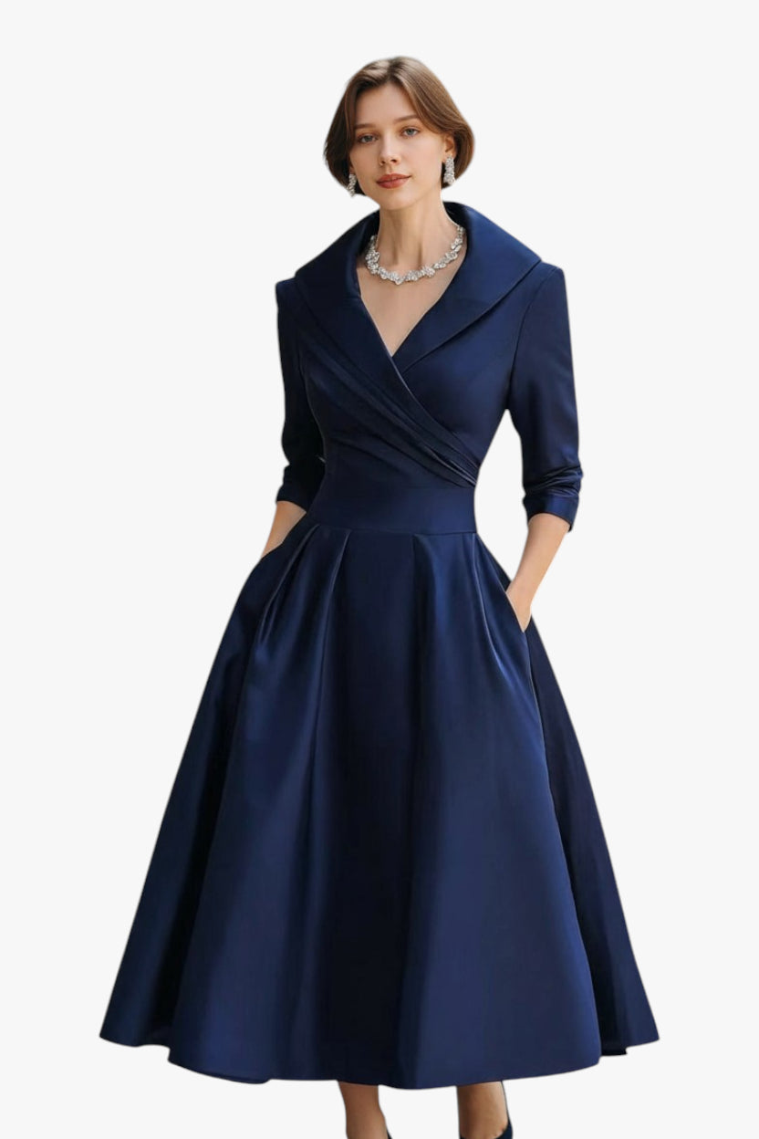 Woman wearing a navy blue dress with a white background