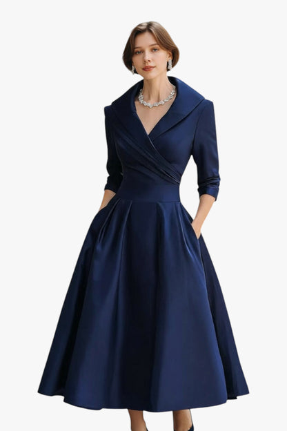 Woman wearing a navy blue dress with a white background