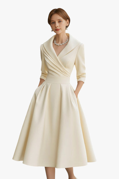 Woman wearing a cream-colored dress with a white background